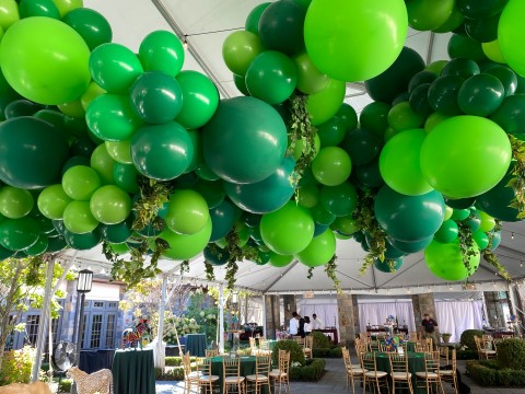 Amazing Jungle Inspired Balloon Garland with Greenery over Tent Ceiling and Custom Life Size Animal Cut Outs for Bar Mitzvah Party Decor