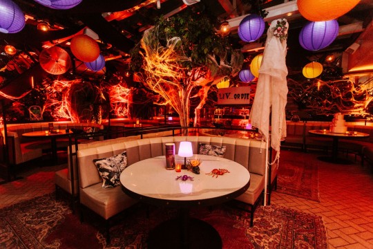 Halloween Inspired Ceiling Treatment with Purple and Orange LED Lanterns, Custom Votives as Centerpiece, Custom Printed Sign and Orange Up Lighting Around the Room