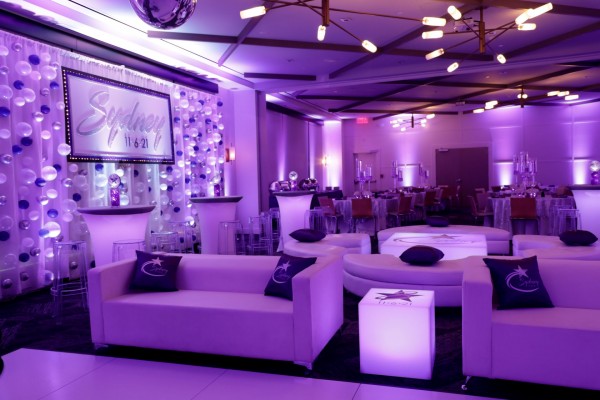 Custom LED Lounge Setup with Custom Pillows and Coffee Tables, LED High Tops, Beautiful Purple Uplighting, Custom Backdrop and Bubble Balloon Wall