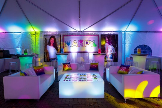 Beautiful Tent Party Decor with Custom LED Lounge, Colorful Logo Pillows, Custom Uplighting, Coffee Table and High Top Setup