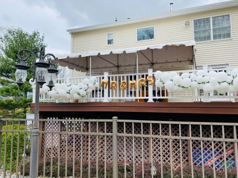 Organic Balloon Garland with Letter Over Fence for Outdoor Wedding Decor