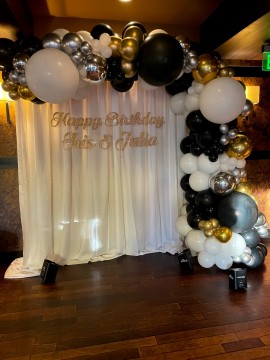 Beautiful Black and White Organic Balloon Arch Metallic Silver & Gold Accent Over Pipe and Drape Custom Hand Cut Signage for 18th Birthday Party