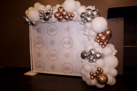 Organic White Half Balloon Arch with Metallic Silver and Copper Orbz over Step and Repeat for Sweet Sixteen