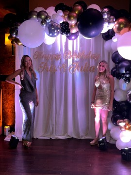 Birthday Girls with their Beautiful Black and White Organic Balloon Arch with Metallic Silver & Gold Accents Over Pipe and Drape Custom Hand Cut Signage