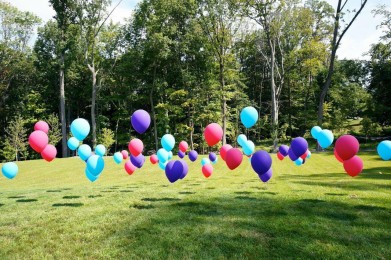 Single Balloons on Golf Tees on Outdoor Lawn