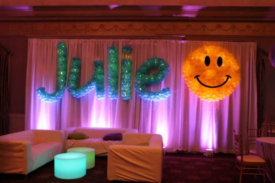 Turquoise Name in Balloons Sculpture on LED Curtain Backdrop with Smiley Face Sculpture