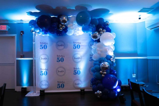 Custom Step & Repeat for 50th Birthday Party with Organic Balloon Garland & Uplighting